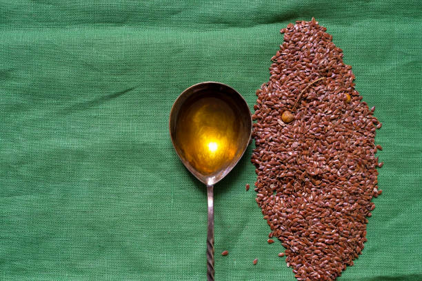 istock Flax seeds. Spoon filled with linseed oil. Green background. 2030594882
