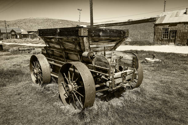 Classic sepia toned image of an old antique horse drawn wagon and mining ghost town of Bodie State Historic Park California, USA.