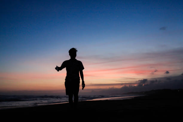 silhouette of people walking on the beach