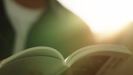 Close-up hand of man reading a book.