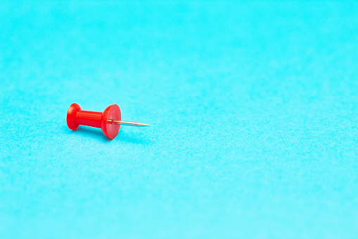 Close-up of a single red pushpin.