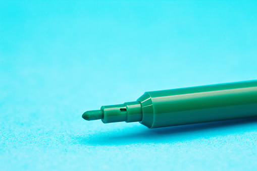 Tight close-up shot of a green felt-tip pen with copy space.