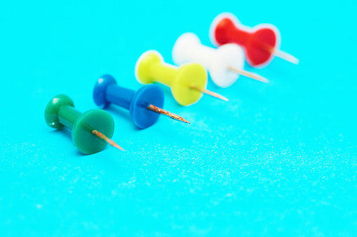 Group of multi-colored pushpins in tight close-up.