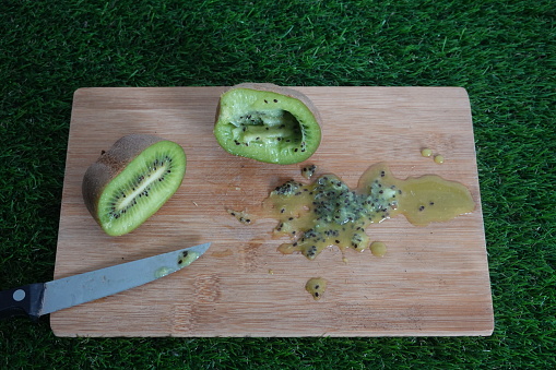 kiwi fruit cut in half to remove seeds for sowing. kiwi seeds on the board