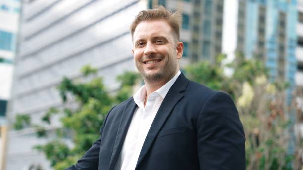 istock Smart caucasian business man looking at camera while standing at rooftop. Urbane 2030676017