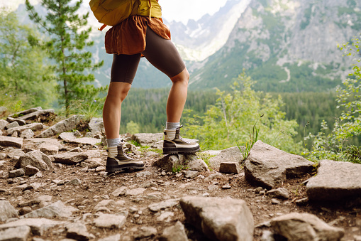 Image of hiker legs standing on a hiking path and looking at the view. The concept of nature.