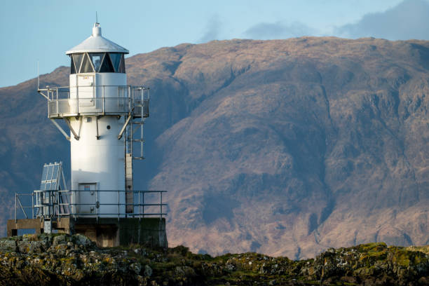 istock Sentinel of the Sea: Port Appin Coastal Lighthouse Against Mountain Backdrop 2030682251