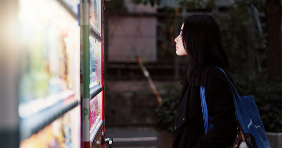 Travel, train station and Japanese woman in underground Tokyo terminal for public transport schedule. Subway, map and guide with young tourist reading information for sightseeing trip or journey