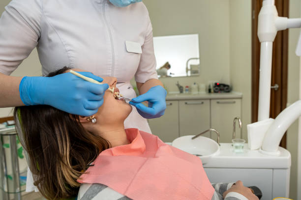 istock Dentist's hand holding tooth color and examining patient's teeth 2030723027