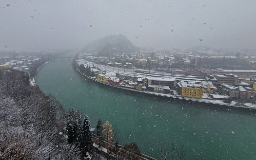 Kufstein, Austria. Inn River bank in Kufstain and buildings on a winter snowy day. Overview of the city of Kufstein Tirol and river Inn in Winter