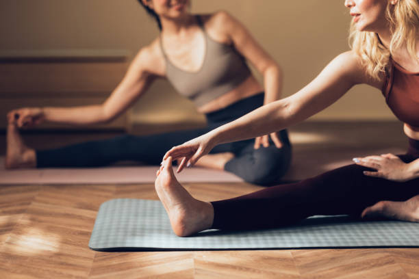 istock Two Women in Activewear Doing Stretching Exercises on Yoga Mats 2030734101