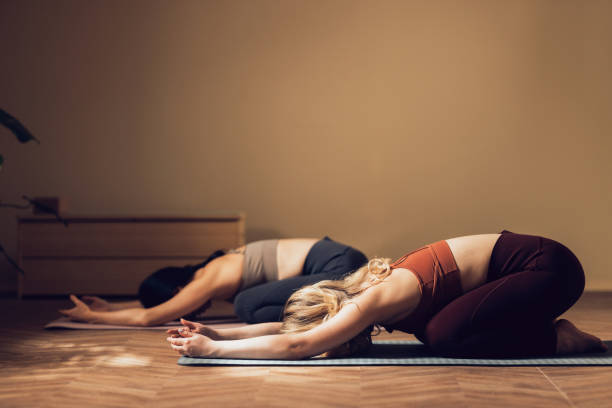 istock Two People Practicing Yoga Child's Pose in Serene Indoor Setting 2030734106
