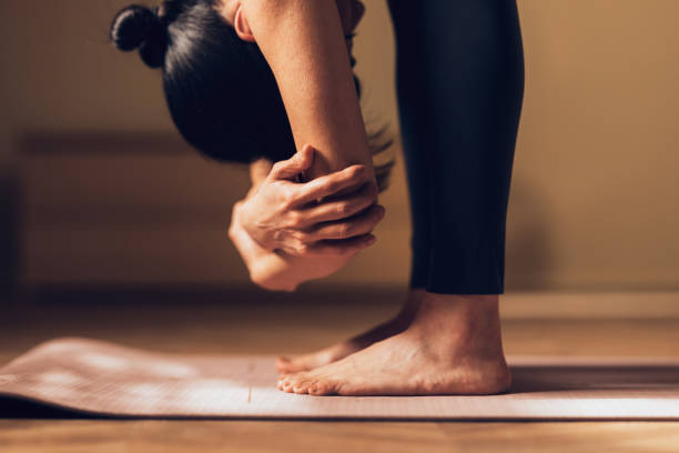 Adult Practicing Yoga, Intense Forward Bend Pose on Mat