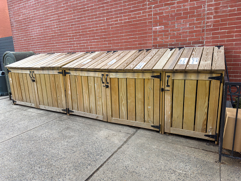 Wooden trash enclosures in front of of a residential building