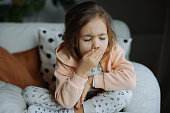 Sick little girl coughing in living room