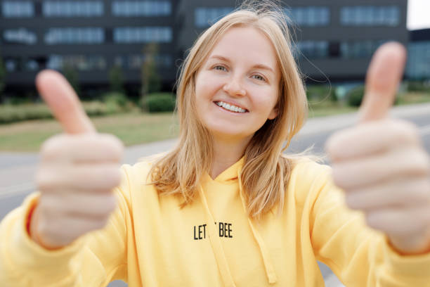 istock Image of a happy optimistic emotional young student posing over city background dressed casual, showing thumbs up gesture. Lifestyle concept. 2030764860