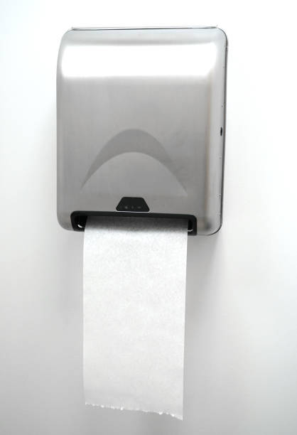 Toilet paper roll neatly placed on a chrome wall holder. Simple bathroom design with clean white tiles. Modern restroom essentials for home or office spaces.