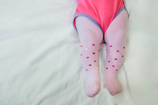 Legs of a small child in pink tights