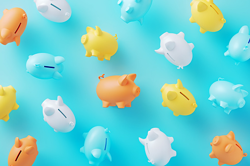 Colorful piggy banks on blue background. Horizontal composition.
