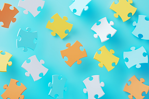 Colorful jigsaw puzzle pieces on blue background. Horizontal composition.