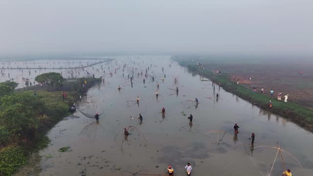 Aerial view of a winter fishing festival on a misty lake, Bangladesh.