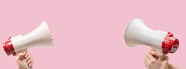 istock Megaphone in woman hands on a pink background. 2030857990