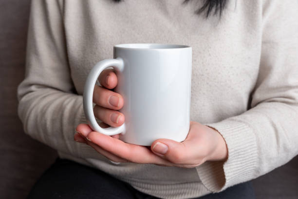 istock Woman's hands hold a pristine white mug, providing a perfect canvas for promoting mug designs 2030867508