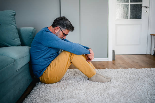 istock Depressed man sitting alone on the floor 2030869634