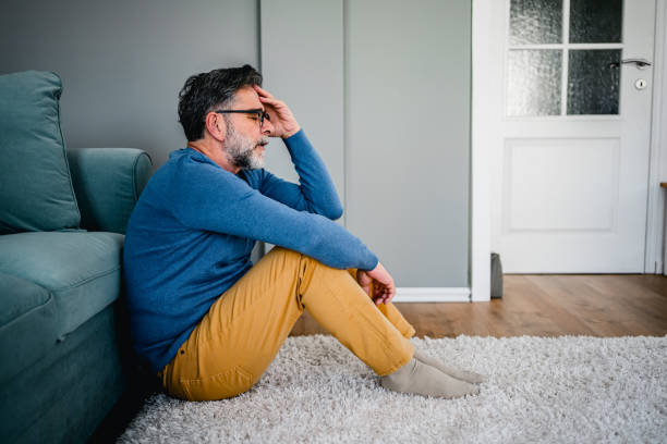 Depressed man sitting alone on the floor