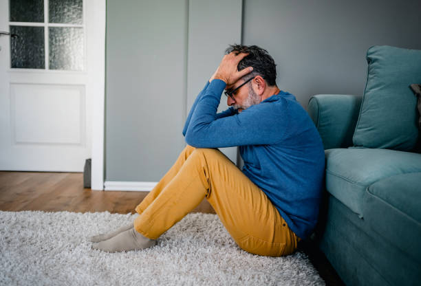 istock Depressed man sitting alone on the floor 2030875969