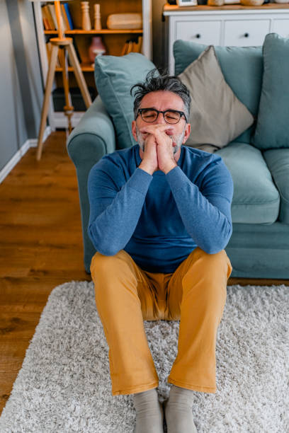 istock Depressed man sitting alone on the floor 2030883475