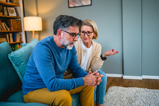 Worried mature couple talking about problems at home