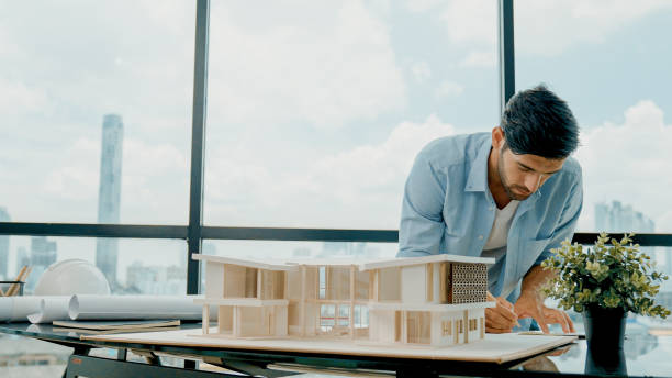 istock Closeup of skilled engineer check, inspect, look at house model. Tracery 2030901111