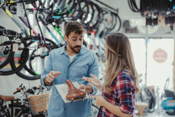 istock Bicycle Salesman Talking With Female Customers 2030906362