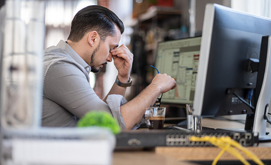 Shot of a stressed out man working in a demanding career