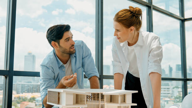 istock Skilled architect team discussion about house model construction. Tracery 2030947462