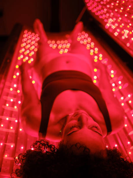 istock Woman On an LED Bed Receiving Red Light Therapy 2030972104