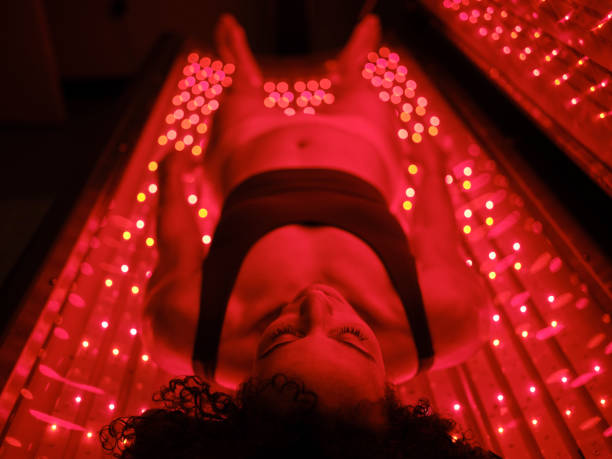 istock Woman On an LED Bed Receiving Red Light Therapy 2030973138
