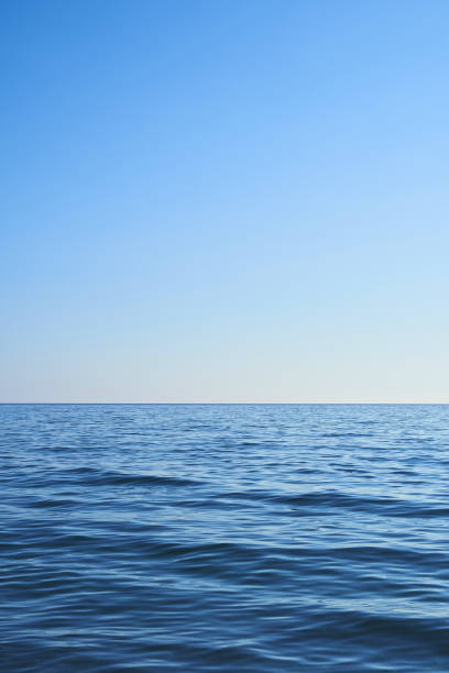 istock Blue water from the sea with a blue sky. Light comes from the right. Vertical format, also suitable as a poster or background. Free space for text, objects or other things. 2030975718