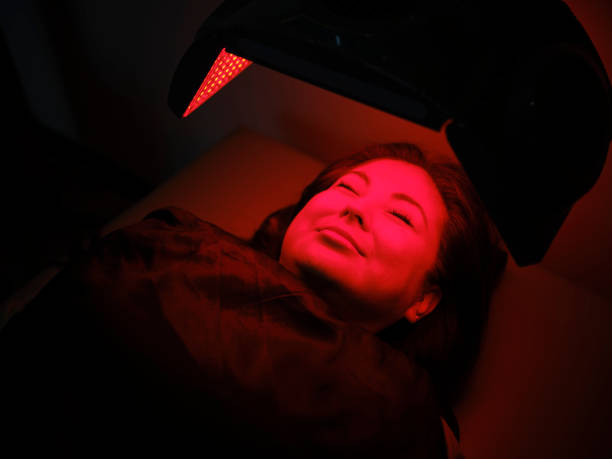 istock Woman On an LED Bed Receiving Red Light Therapy 2030976768