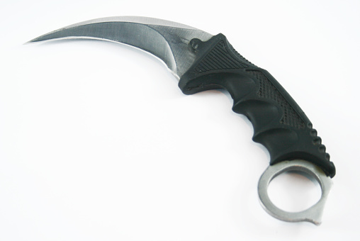 Curved knife blade karambit at the white background