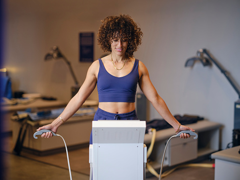 A woman in a biohacking facility, using a body composition analysis machine.
