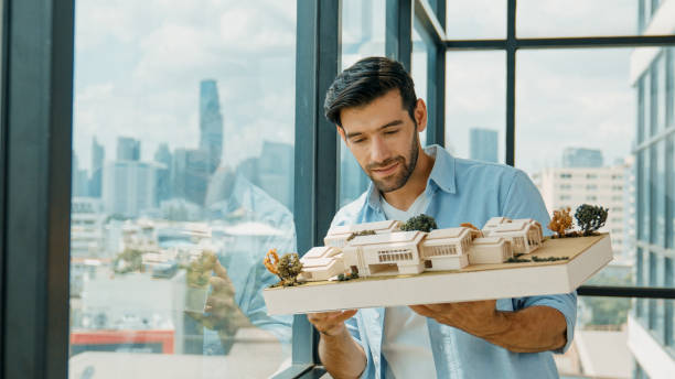 istock Businessman holding house model while checking house construction. Tracery 2031002419