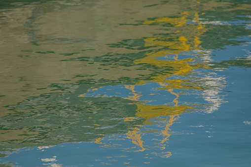 Water in the harbour close to Lake Ontario reflecting the colours around it.