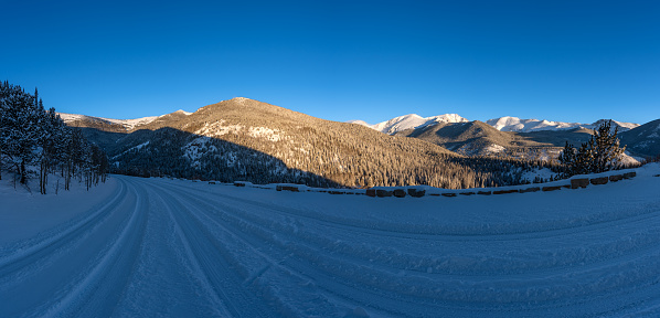 Snow covered road through the extreme winter terrain of Rocky Mountain National Park near Estes Park, Colorado USA.