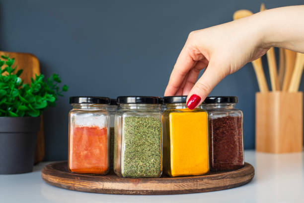 istock Cropped hand holding jar of spices on kitchen. 2031046393