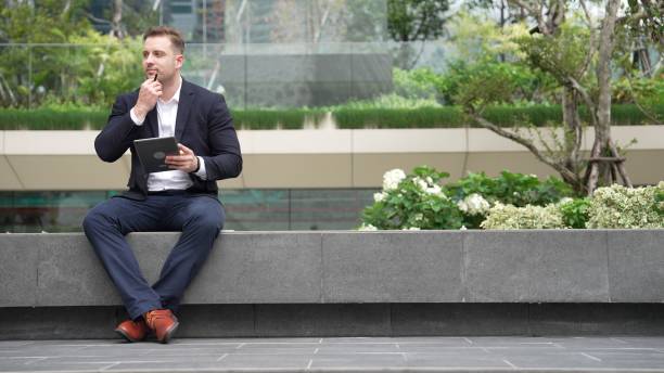 istock Smart businessman sitting while writing on tablet and planning strategy. Urbane 2031059681