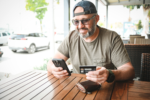 man paying with a credit card in a cafe