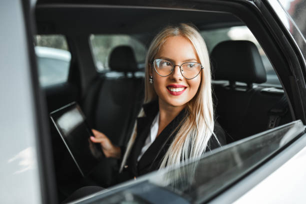 istock Cute Smiling Businesswoman Using Digital Tablet To Work While Traveling By Car 2031080495