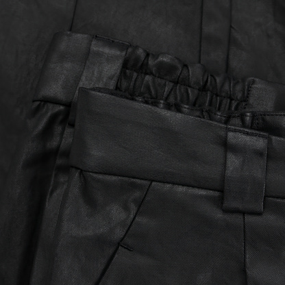 Detail of a black waxed trouser belt with loop and pocket close up